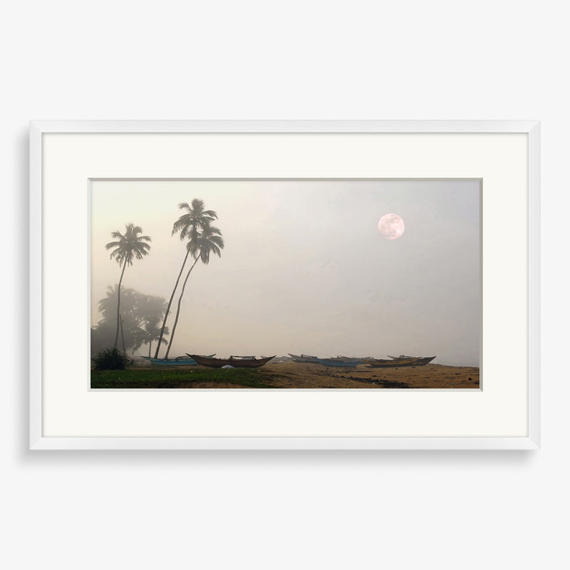 Large wall art featuring beach scene at dusk with moon. 